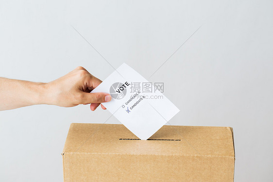 投票公民权利人民男手把两名候选人的投票放入选举的投票箱图片