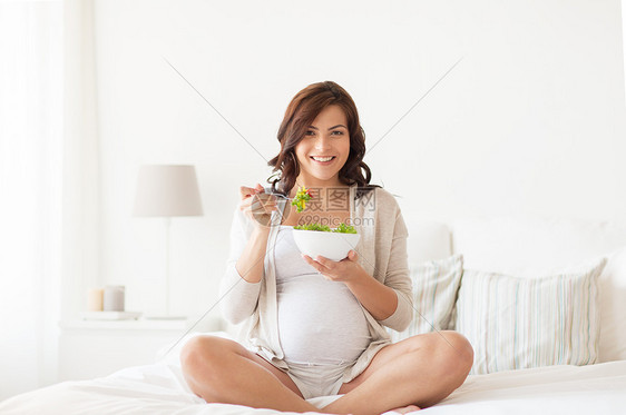 怀孕,健康的食物人们的快乐的孕妇家吃蔬菜沙拉图片