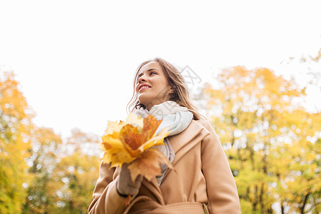 季节人的美丽的轻女人带着枫叶走秋天的公园里秋天公园里枫叶的漂亮女人图片