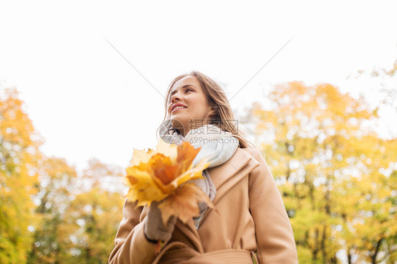 季节人的美丽的轻女人带着枫叶走秋天的公园里秋天公园里枫叶的漂亮女人图片