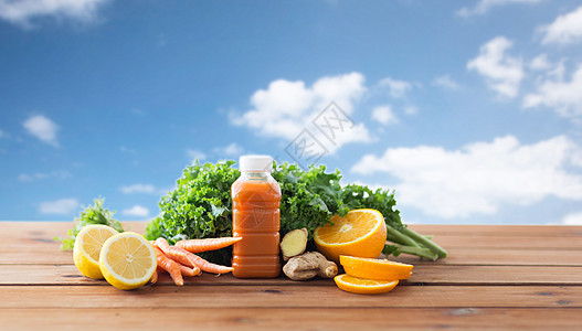 健康的饮食,食物,节食素食的瓶子与胡萝卜汁,水果蔬菜木制桌子上的蓝天背景图片