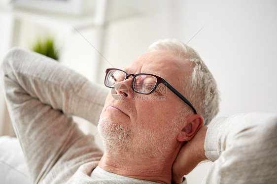 老舒适人的戴眼镜的老人家沙发上放松图片