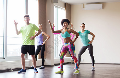 健身,运动,舞蹈健康的生活方式群微笑的人与教练健身房工作室跳舞图片