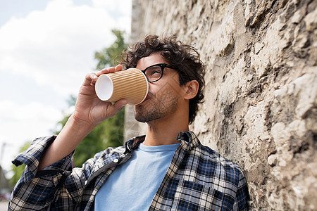 生活方式,饮料人的戴眼镜的人喝咖啡次纸杯石街墙图片