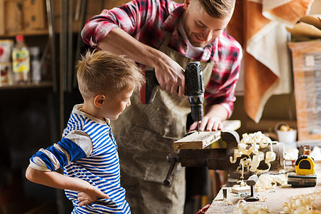家庭,木工,木工人的父亲小儿子车间用钻孔木板图片