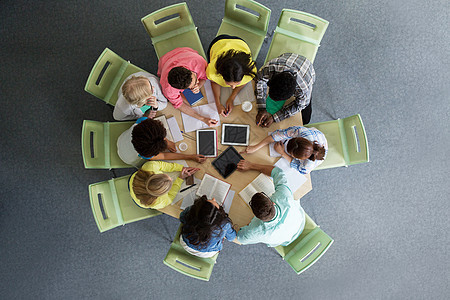 教育,高中,人技术群国际学生坐桌子上,平板电脑电脑,书籍笔记本顶部大学图书馆图片