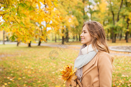 季节人的美丽的轻女人带着枫叶走秋天的公园里秋天公园里枫叶的漂亮女人图片