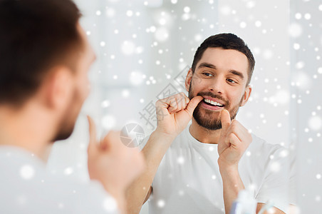 保健,牙科卫生,人美容微笑的轻人用牙线清洁牙齿,并家里的浴室看镜子雪图片
