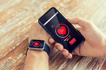 技术,保健,应用人的近距离的男手智能手机,穿着智能手表与红色心脏图标屏幕上测量脉搏图片