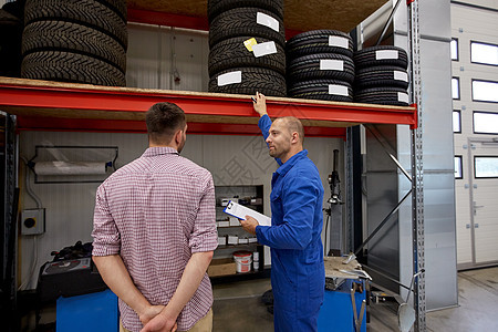汽车服务,维修,维护人的机械师与剪贴板轮胎给人汽车商店图片