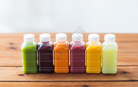 健康饮食,饮料,饮食包装塑料瓶与同的水果蔬菜汁木制桌子上图片