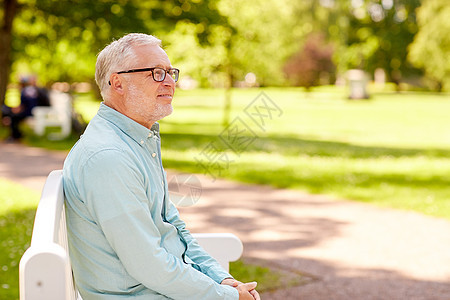 老人人的快乐的老人戴着眼镜坐夏季公园戴眼镜的快乐老人坐夏天的公园里图片