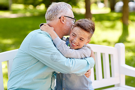 家庭世代关系人的快乐的祖父孙子夏天公园的长凳上拥抱图片