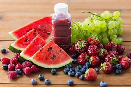 健康的饮食,食物,节食素食的瓶子与水果浆果汁冰沙木制桌子上图片