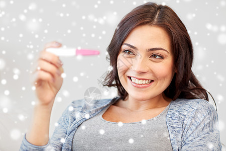 生育,冬天,母人的快乐的微笑女人看着怀孕测试家里下雪图片