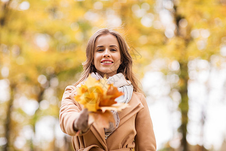 季节人的美丽的轻女人带着枫叶走秋天的公园里秋天公园里枫叶的漂亮女人图片