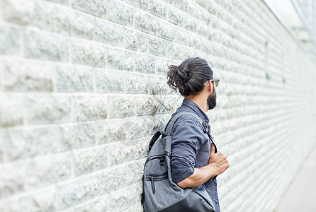 旅行,旅游,生活方式人的男人背包站城市街道墙上背景图片