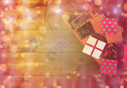 节日,诞节,广告,新庆祝许多小礼品盒上的红色木制雪橇灯光图片
