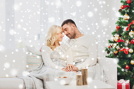 家庭,诞节,假日,爱人的幸福的夫妇覆盖着格子坐家里的沙发上图片