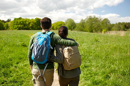背包行走的人旅行,徒步旅行,背包旅行,旅游人们的幸福的夫妇与背包拥抱沿着乡村道路行走背景