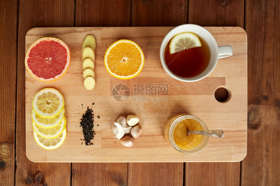 健康,传统医学,民间补救民族科学杯姜茶与蜂蜜,柑橘大蒜木板上图片