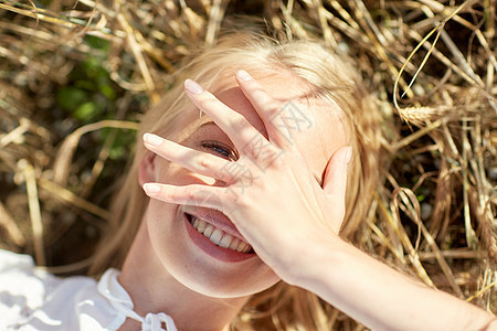 自然,暑假,假期人的接近快乐的轻女人躺谷类作物上,用手遮住脸图片