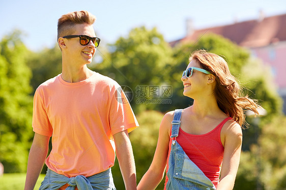 假期,爱人的快乐微笑的青少夫妇夏天的公园里散步互相看着图片