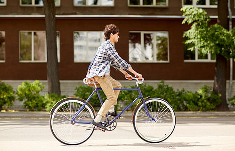 人,风格,休闲生活方式轻的时尚男子肩袋骑固定齿轮自行车城市街道图片