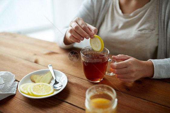 健康,传统医学民族科学的密切妇女添加柠檬茶杯图片