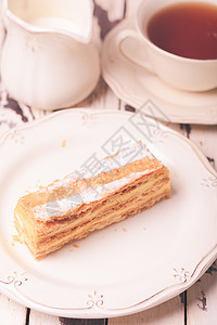 白色盘子上用奶油奶油泡制糕点可爱的破仑蛋糕图片
