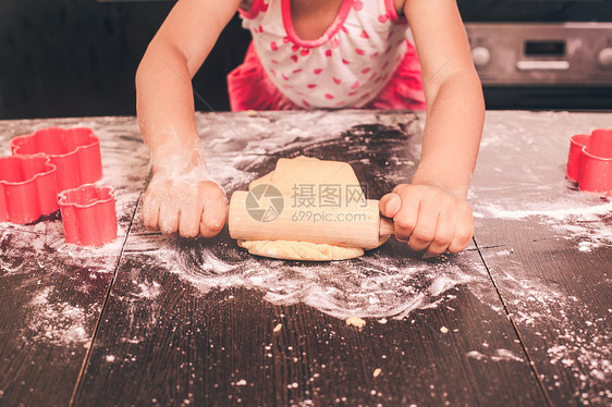 小可爱的女孩厨房里伸展快乐的小厨师图片