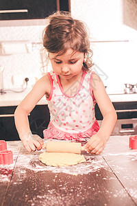 小可爱的女孩厨房里伸展快乐的小厨师图片
