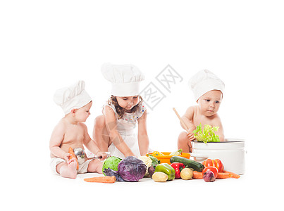 三个婴儿三个孩子玩蔬菜小厨师白色上隔离小厨师饭背景