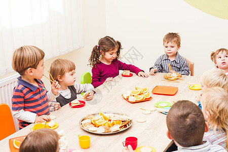 孩子们坐桌子旁吃午饭,吃水果蛋糕幼儿园吃午饭图片