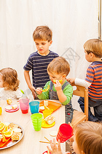 孩子们坐桌子旁吃午饭,吃水果蛋糕幼儿园吃午饭图片