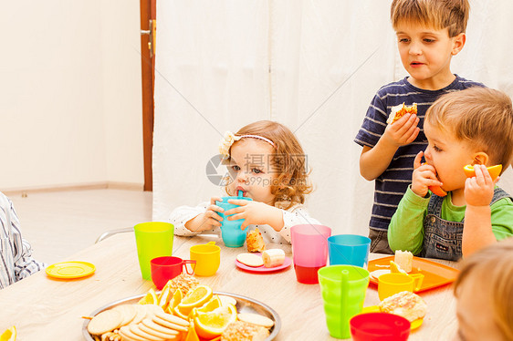 孩子们坐桌子旁吃午饭,吃水果蛋糕幼儿园吃午饭图片