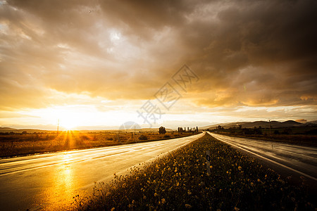 潮湿的道路天空雨后的湿路田野上的日落图片