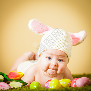 三个月的婴儿躺他的肚子上,就像复活节兔子草地上带着鸡蛋复活节小兔子图片