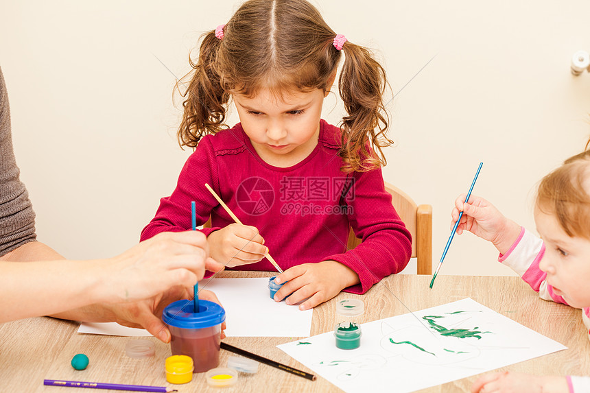 女孩正幼儿园用画笔水彩画纸上女孩画画图片