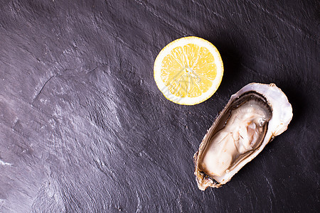 石板背景上的牡蛎肉质柠檬牡蛎加柠檬图片