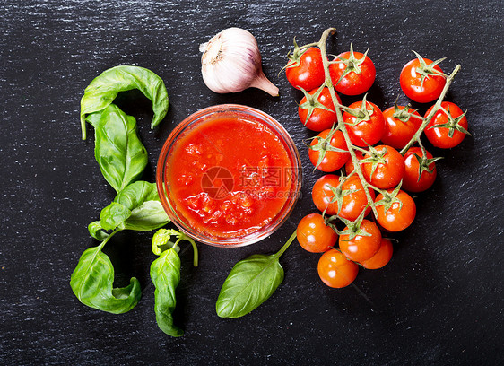 碗番茄酱与新鲜罗勒,大蒜西红柿,顶部视图图片