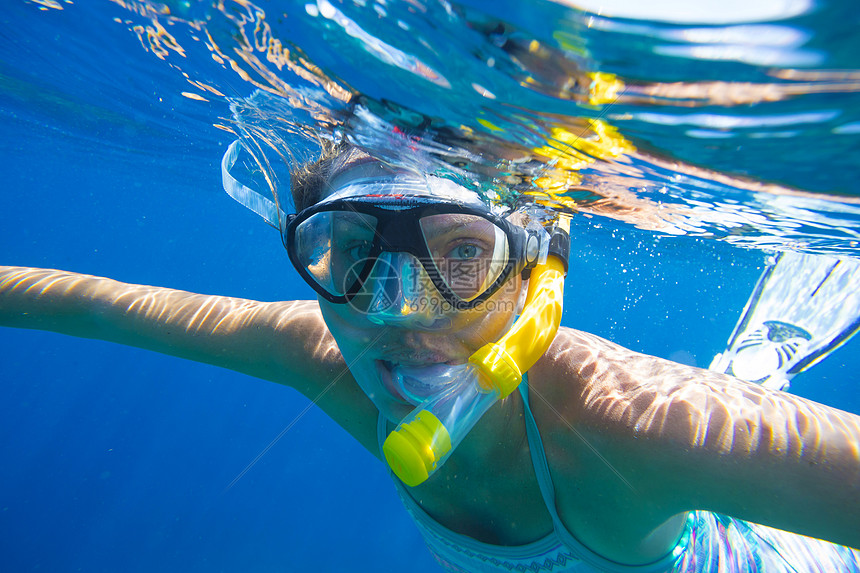 轻的女人热带水中浮潜图片
