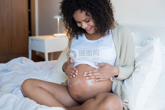 非洲孕妇滋润她的腹部图片