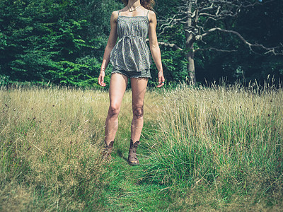 个轻的女人站个阳光明媚的夏天,森林的空地旁的草地上图片