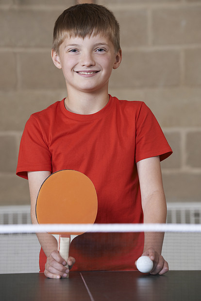 学校体育馆打乒乓球男孩的肖像图片