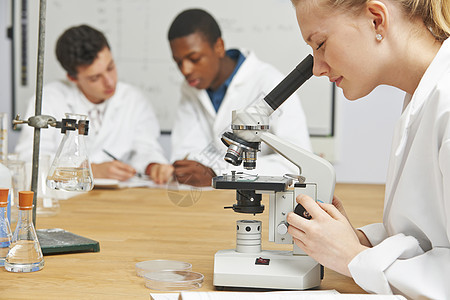 理科的十几岁学生用显微镜背景图片