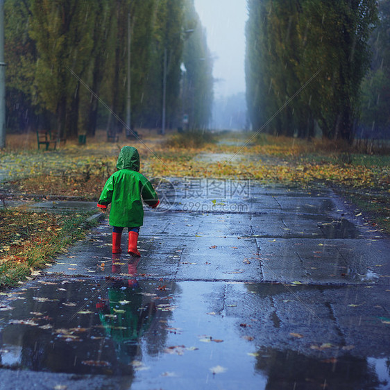 蹒跚学步的孩子秋雨公园跑步图片