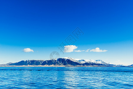 蓝色的海洋,背景遥远的山脉图片