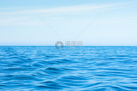 波浪状的蓝色海洋,蓝天上云图片