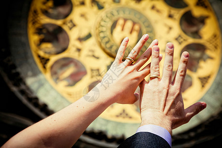 捷克共国布拉格旧市政厅墙上的时钟背景上新婚的手高清图片